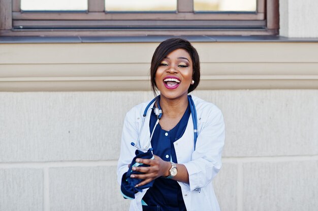 Femme médecin afro-américaine avec stéthoscope posé en plein air