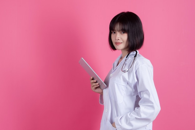 femme médecin asiatique avec blouse blanche sur rose