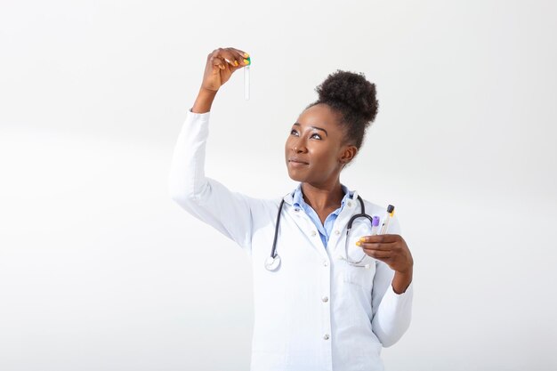 Femme médecin en blouse blanche tenant des tubes à essai sanguin dans les mains tout en travaillant au laboratoire moderne