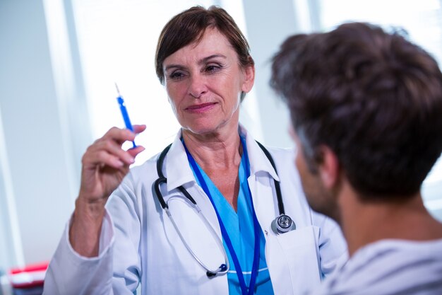 Femme médecin donnant une injection à un patient