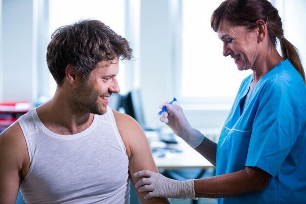 Femme médecin donnant une injection à un patient