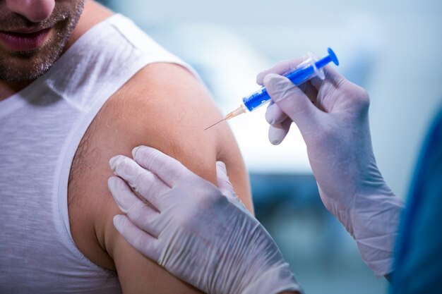 Femme médecin donnant une injection à un patient