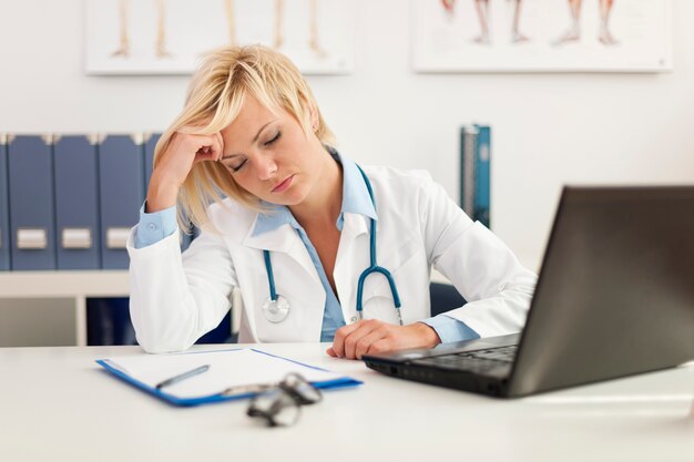 Femme médecin épuisée au bureau