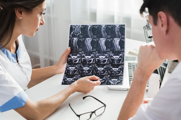 Femme médecin expliquant une radiographie au patient