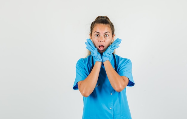 Photo gratuite femme médecin ouvrant les paumes près de la bouche en uniforme bleu