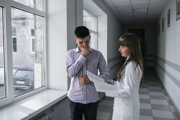 Femme médecin et patient dans le couloir