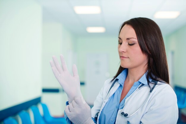 Femme médecin portant des gants chirurgicaux