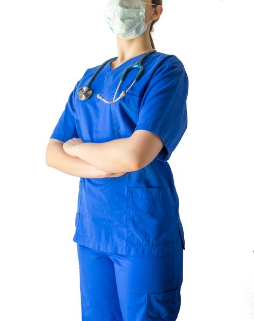 Femme médecin portant un uniforme médical bleu et un masque debout en toute confiance avec les mains croisées