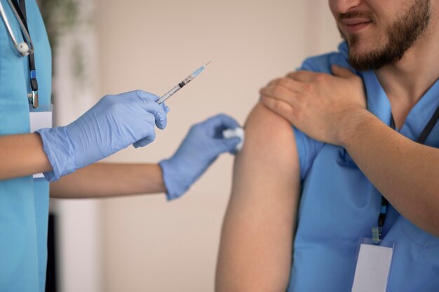 Femme médecin prépare la vaccination pour son collègue