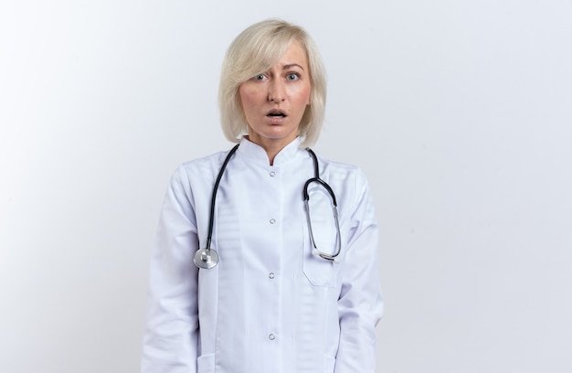 Femme médecin slave adulte anxieuse en robe médicale avec stéthoscope regardant la caméra isolée sur fond blanc avec espace de copie