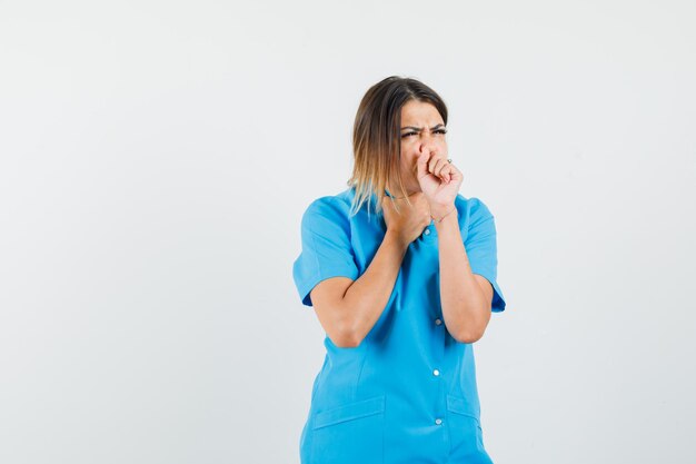 Femme médecin souffrant de toux en uniforme bleu et ayant l'air malade