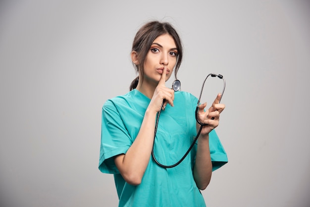 Femme médecin avec stéthoscope faisant signe