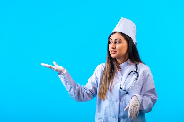 Femme médecin avec stéthoscope introduisant quelque chose et souriant.