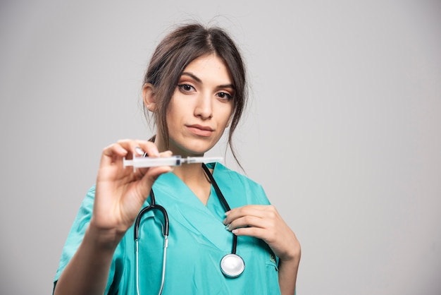 Femme médecin, à, stéthoscope, tenue, seringue