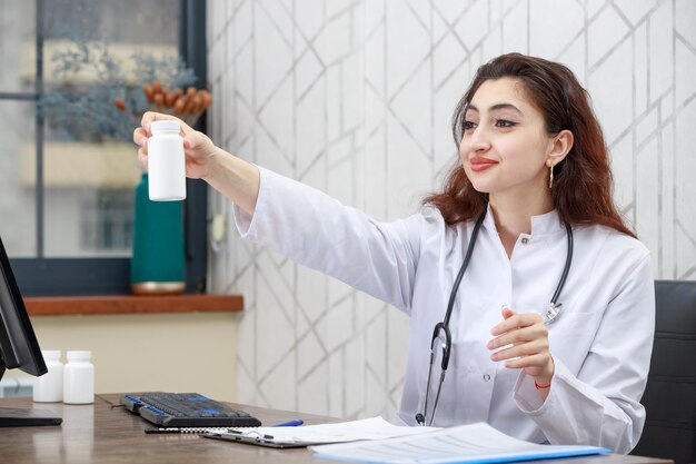 Femme médecin tenant une capsule de médicament et souriant Photo de haute qualité