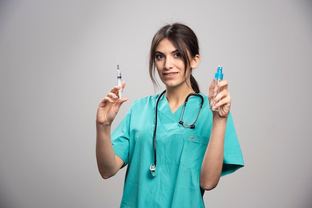 Femme médecin tenant un flacon pulvérisateur et une seringue
