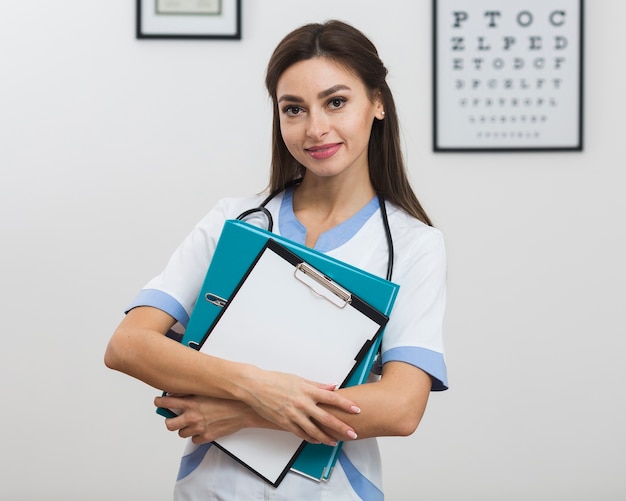 Photo gratuite femme médecin tenant un presse-papiers et un dossier