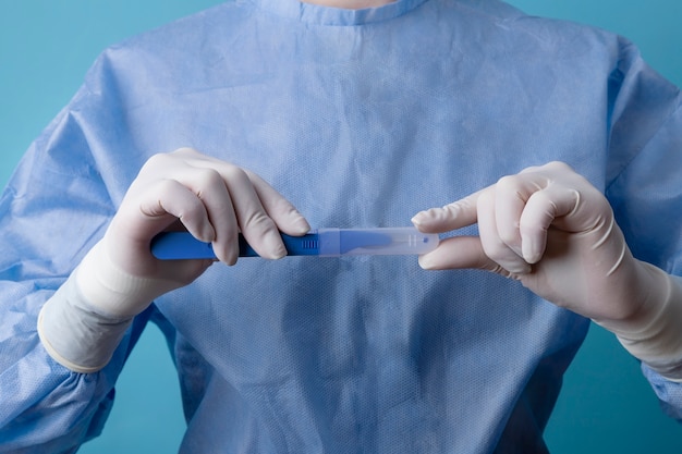 Femme médecin tenant un scalpel médical métallique