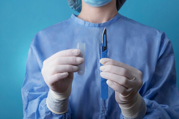 Femme médecin tenant un scalpel médical métallique