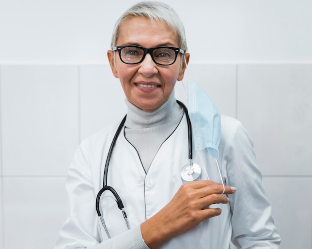 Femme médecin tenant son masque médical sur l'épaule