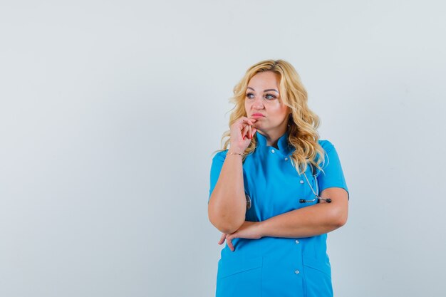 Femme médecin en uniforme bleu à côté et à l'espace insatisfait pour le texte