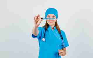 Photo gratuite femme médecin en uniforme tenant tube à essai et souriant