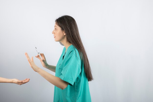 Femme médecin en uniforme vert se faire tirer sur le blanc.