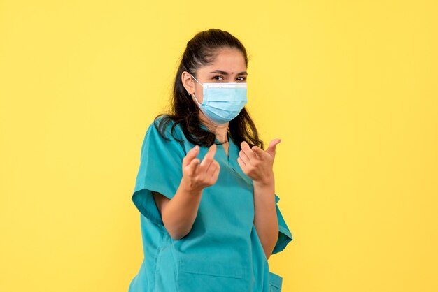 Femme médecin de la vie avant avec masque pointant avec les doigts à l'avant