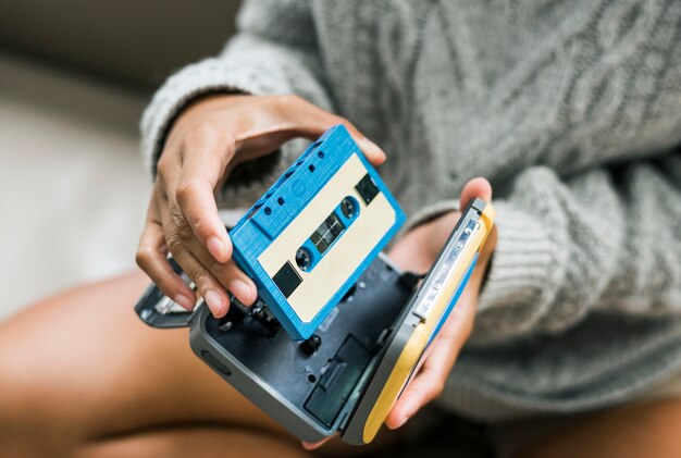 Femme mettant une cassette dans un lecteur de cassettes