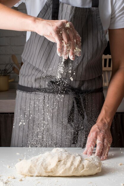 Femme mettant de la farine sur la pâte