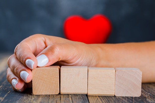 Photo gratuite femme mettant la main sur des cubes en bois