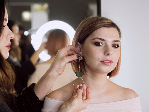 Femme, mettre, boucles d'oreilles, modèle