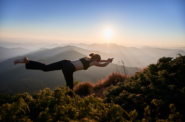 Femme mince faisant des exercices de yoga sur la nature