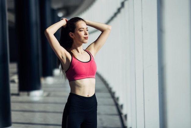 Femme mince sportive avec queue de cheval fitness femme aime l'exercice d'entraînement au gymnase