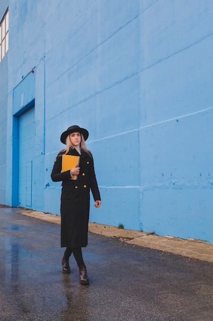 Photo gratuite femme à la mode marchant sur un jour pluvieux