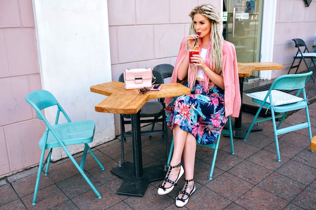 Femme à la mode à la mode élégante portant une tenue élégante féminine, boire un cocktail au restaurant