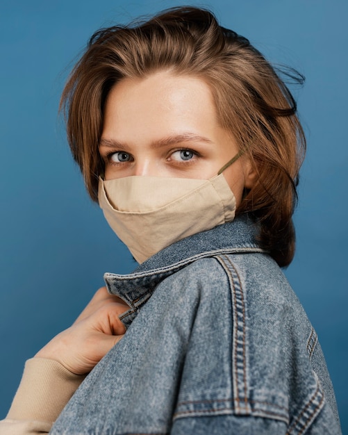 Femme à la mode portant une veste en jean et un masque