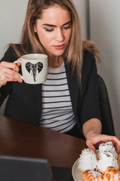 Femme moderne avec café et pâtisserie