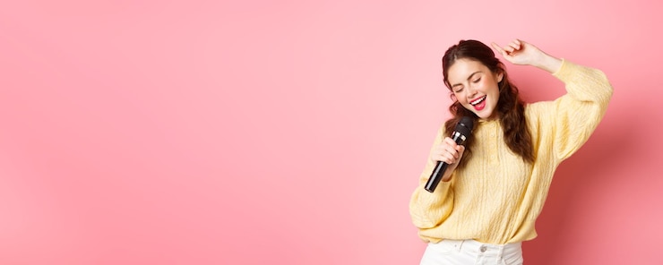 Photo gratuit femme moderne insouciante dansant et chantant une chanson dans un microphone jouant avec un micro souriant et se déplaçant