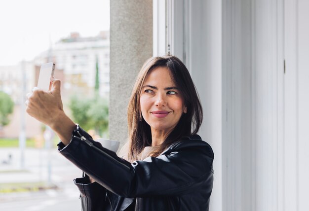 Femme moderne prenant un selfie