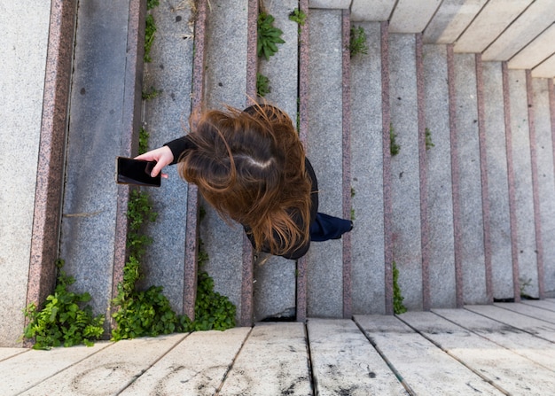 Femme, monter escalier, utilisation, smartphone