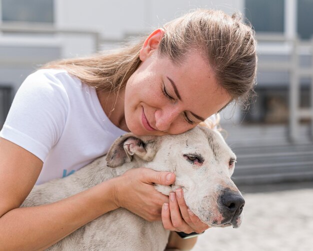 Femme montrant de l'affection pour mignon chien de sauvetage au refuge