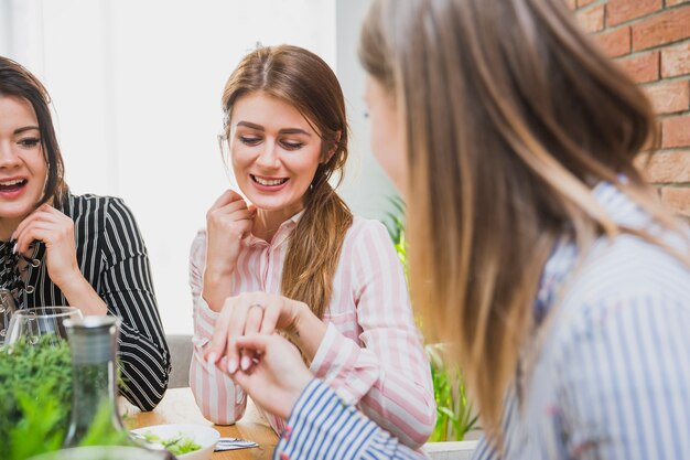 Femme montrant une bague à des amis