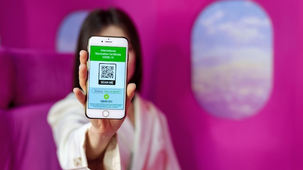 Femme Montrant Un Certificat De Vaccination International Covid19 Avec Code Qr Sur Fond Rose De Téléphone