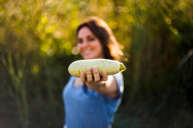 Femme montrant une courge récoltée