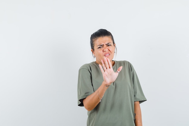 Femme montrant le geste d'arrêt en t-shirt et à l'ennui