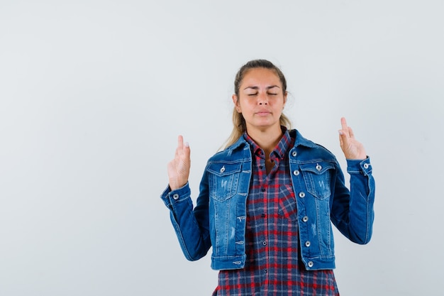 Femme montrant le geste de méditation en chemise, veste et à la vue de face, paisible.