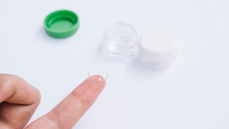Photo gratuit femme montrant des lentilles de contact sur son doigt