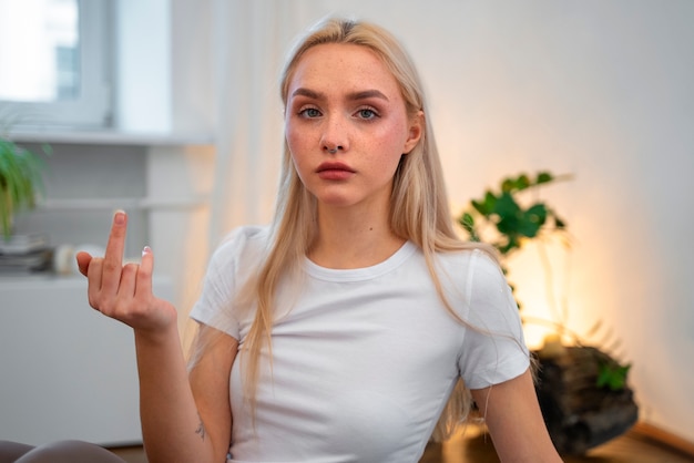 Femme montrant le majeur à la maison pendant l'entraînement