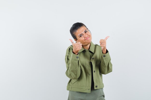 femme montrant les pouces vers le haut en veste, t-shirt et à la confiance